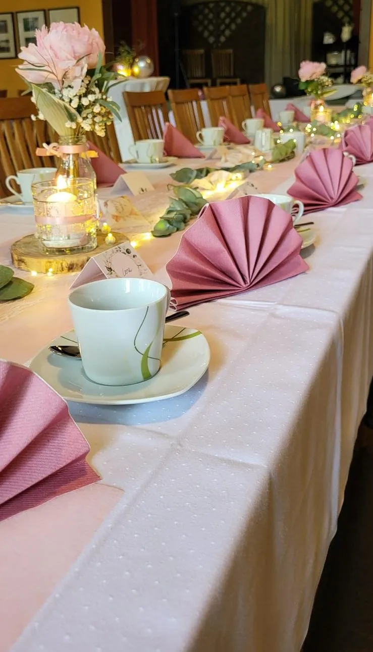 Liebevoll gedeckte Tafel mit Blumen und Kerzen