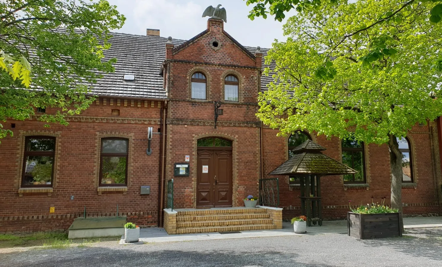 Backsteingebäude des Lindenkrug Großbahren mit Linden vor dem Eingang